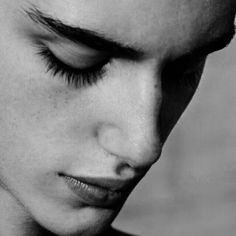 a black and white photo of a young man with his eyes closed, looking down