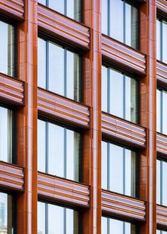 an orange building with lots of windows next to a street sign on the side of it