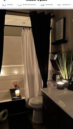 the bathroom is decorated in black and white with touches of greenery on the shower curtain