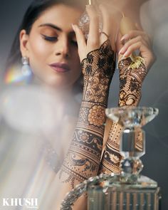 a woman with henna on her arm holding an object in front of her face