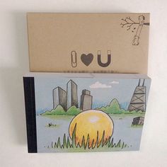 two greeting cards, one with an image of a yellow ball and the other with a drawing of a city