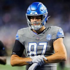 a close up of a football player wearing a helmet and holding his hands on his chest