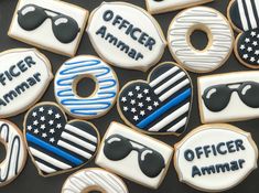 decorated cookies with the words officer and an american flag are arranged in rows on a black surface