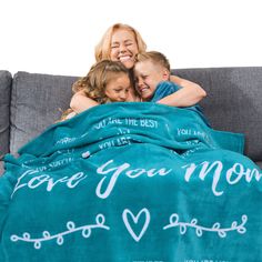 two girls and a boy cuddle under a blanket that says, i love you mom