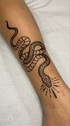 a tattoo on the arm of a person with a black and white snake design on it