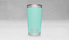 a mint green yeti tumbler cup sitting on top of a white countertop