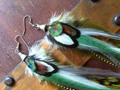 "Long and beautiful feather earrings with a boho hippie feel. These have a lovely combination of greens mixed with white, grizzly, and grey. Finished with a bead cap, and ear hooks with stoppers so you so not loose your feathers. Light as a feather, layered, 8-9\" long You will look fab and will be the envy of the room! If you prefer clip on's or hooks leave a note at check out...no extra charge. shipped in a gift box for safe travel and storage. Gift wrap is free. If you would like this please Purple Feather, Light As A Feather, Boho Green, Cluster Earrings, Ear Hook, Feather Earrings, Bead Caps, Boho Hippie, Shades Of Green