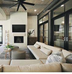 a living room with couches and a ceiling fan in the middle of the room