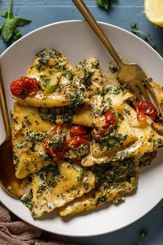 a white plate topped with ravioli covered in cheese and tomatoes