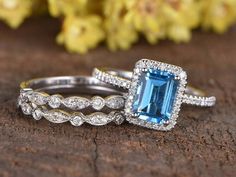 two wedding rings with an aqua blue stone and diamond band on top of each other