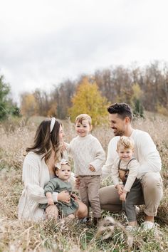 a man and woman with two children in a field