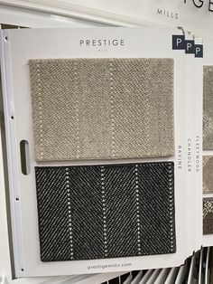 a display in a store with different shades of fabric on it's sides and the words prestige written above them