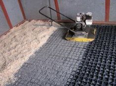 a machine that is on top of some concrete and cement flooring in front of a building