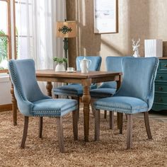 a dining room table with blue chairs and a brown rug on the floor in front of it