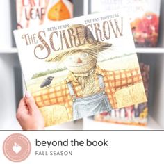 a person holding up a book in front of bookshelves with the title beyond the book