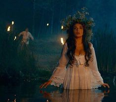 a woman in white dress standing in water