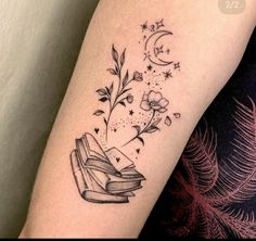 a tattoo with a book and flowers on it