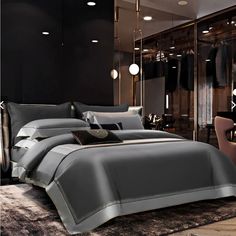 a bedroom with black walls and grey bedding