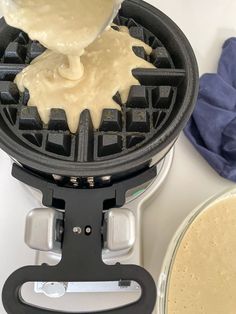 a waffle maker being used to make some type of cream cheesecake with syrup