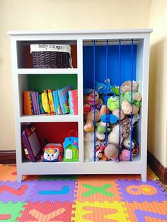 a white bookcase filled with lots of toys on top of a colorful carpeted floor