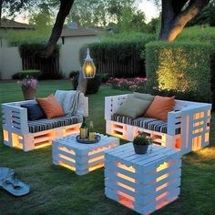 outdoor furniture made out of pallets is lit up in the evening time with lights