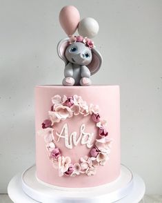 a pink and white cake with an elephant on top