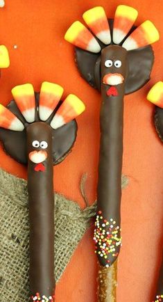 three turkey shaped chocolate sticks with sprinkles on them, one decorated like a turkey and the other made out of candy