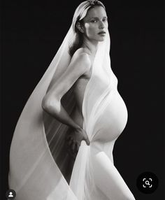 a black and white photo of a woman in a wedding dress with veil on her head