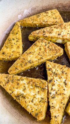 there are some pieces of bread in the pan with brown sauce on it and sprinkled with black pepper