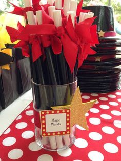 red and white flowers in a glass vase on a polka dot tablecloth with black plates