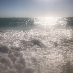 the sun is shining over the ocean waves