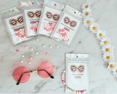 three packages of pink sunglasses and some pearls