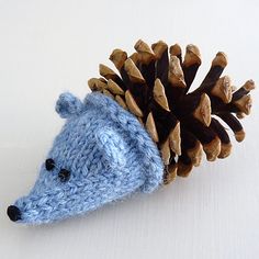 a knitted hedgehog with a pine cone on its head