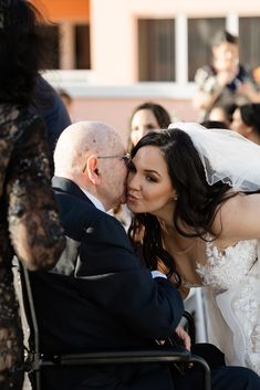 a bride and groom kissing in front of an audience