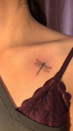 a woman's chest with a small tattoo of a dragonfly on her left side