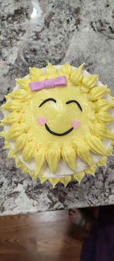 a cake that looks like a sunflower with a pink bow on it's head