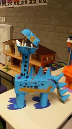 a blue sculpture sitting on top of a white table in a room filled with toys