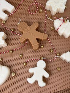 some cookies and other decorations on a brown table with red twine around the edges