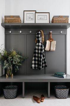 a coat rack with two coats hanging on it next to some baskets and other items