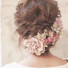 a woman with flowers in her hair wearing a white dress and looking off into the distance