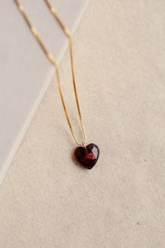 The Charlotte Necklace is a romantic piece featuring a deep red faceted garnet heart stone. This Necklace is handmade with an adjustable length 14k gold-filled chain. The deep red color of the garnet is said to represent love and passion, making this necklace a thoughtful gift for yourself or a loved one. The heart shape makes these earrings an ideal gift for Valentine's Day, an anniversary, or any other day you want to show affection. Wear with Charlotte Garnet Heart Earrings for a perfect matc Heart-shaped Ruby Necklace For Gift, Burgundy Garnet Necklaces For Gifts, Faceted Garnet Necklaces For Gifts, Heart-shaped Garnet Jewelry As Gift, Heart-shaped Garnet Jewelry For Gift, Faceted Garnet Necklace Gift, Garnet Heart-shaped Jewelry For Valentine's Day, Heart-shaped Garnet Jewelry For Valentine's Day, Garnet Jewelry For Valentine's Day Gift