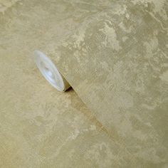 a roll of beige fabric on top of a white table cloth with a circular hole in the middle