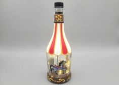 a glass bottle that has some lights in it and a carousel on the inside with horses