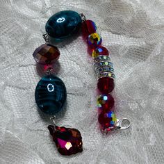 Add some jewelry to your favorite journal with this beaded dangle accessory. Featuring a beautiful pendant with a prism effect, this dangle has beads of red and turquoise accented with silver hardware. The lobster claw clasp allows you to easily clip your dangle to your journal. My beaded dangles are made primarily of upcycled jewelry and are each one of a kind.  Because of this, they may have tiny flaws or imperfections--this is what makes them unique!  Colors may appear differently on screens. Journal Charms, Journal Jewelry, Red And Turquoise, Turquoise Accents, Jewelry Beaded, Red Turquoise, Upcycled Jewelry, Beaded Dangles, Silver Hardware