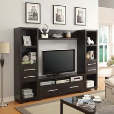 a living room with a large entertainment center and pictures on the wall above it,