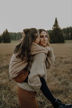 two women hugging each other in a field