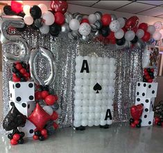 a casino themed party with balloons, dices and streamers in the shape of playing cards