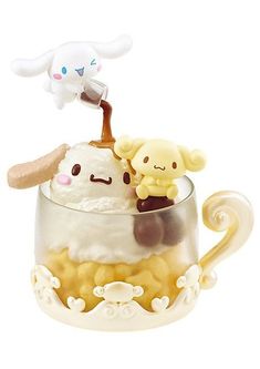 an ice cream sundae with two small toy animals on it's top in a glass cup