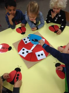 children sitting at a table making ladybugs out of paper