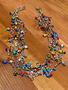 multicolored beaded necklace on wooden surface